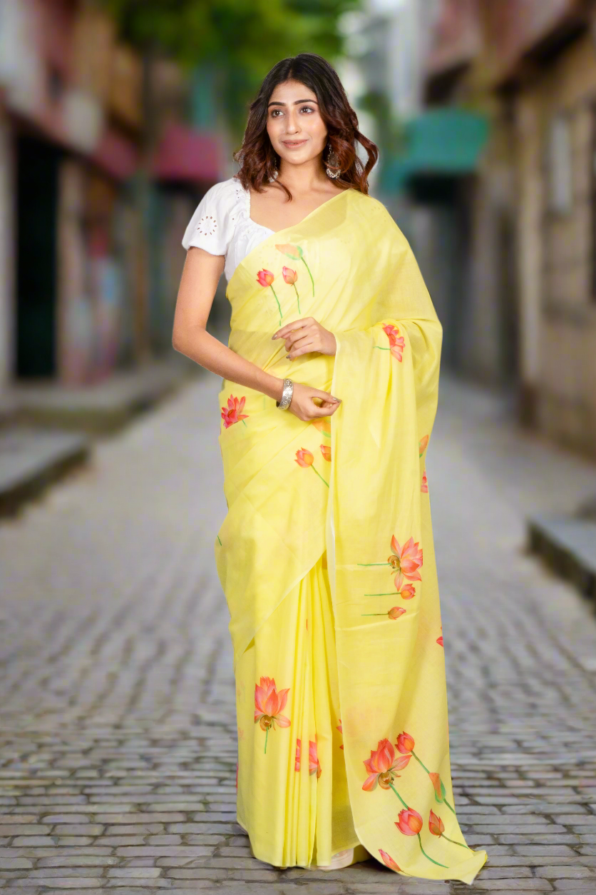 Woman wearing a yellow saree with floral patterns on a gray background