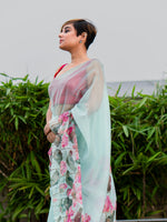 Woman wearing a floral saree with a light background